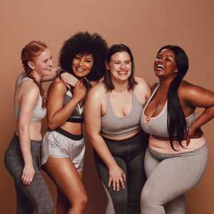 Four diverse women in activewear smiling together, representing Hem’s inclusive product testing community.