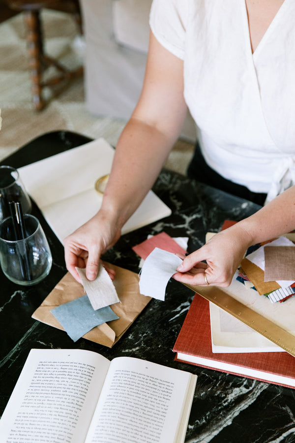 Hands sorting fabric swatches for Hem Support Wear, refined by 100+ women for personalized pelvic floor support.