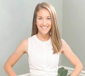 Woman wearing a white tank top with a blurred background